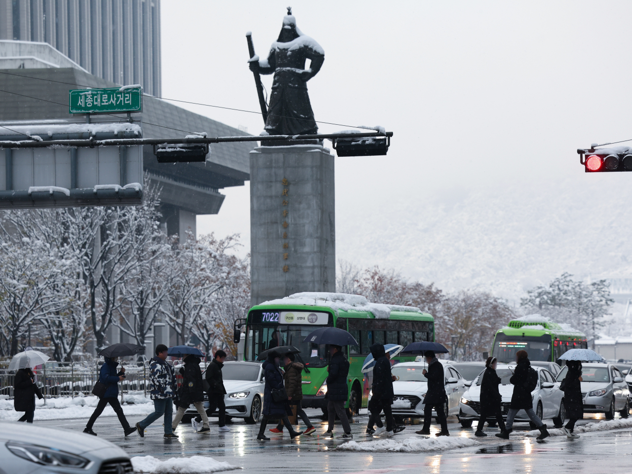 People walk across Gwanghwamun Square in Seoul on Nov. 28, Thursday, as heavy snowfall continued for the second day in a row. (Yonhap)