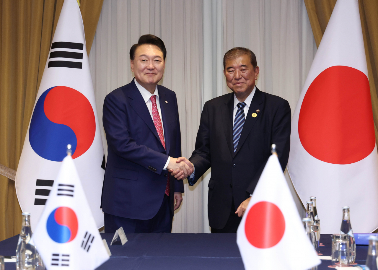 President Yoon Suk Yeol (left) and Japanese Prime Minister Shigeru Ishiba pose for a photo during a summit in Lima, Peru, on Nov. 16, on the sidelines of the Asia-Pacific Economic Cooperation summit. (Yonhap)