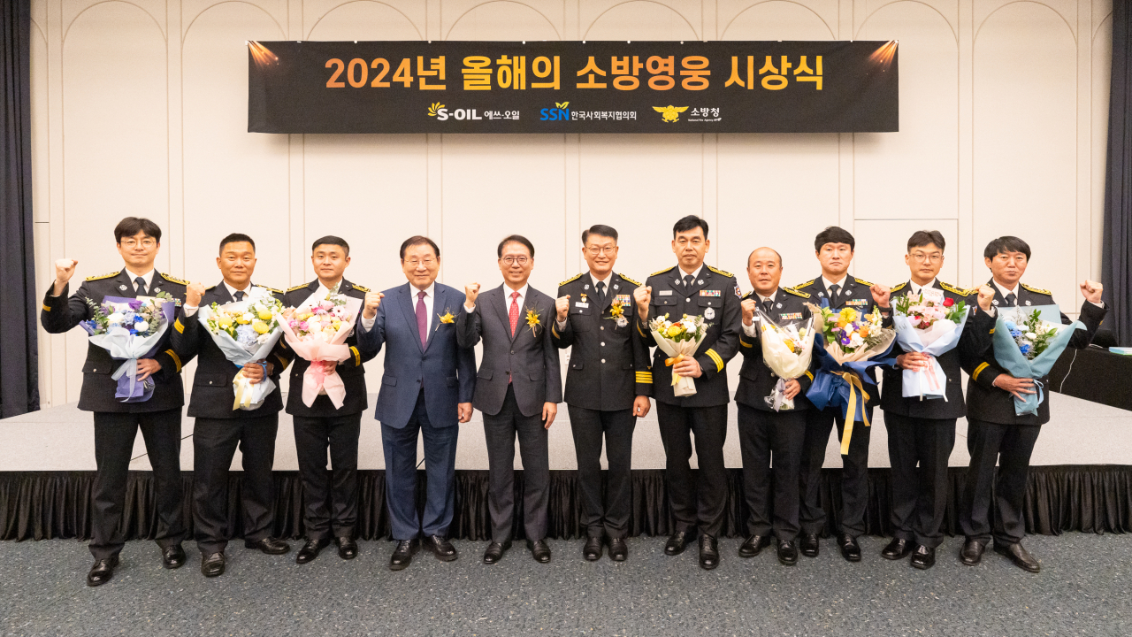 S-Oil President Ryu Yul (fifth from left) and Kim Sung-i (fourth from left), chairman of Korea National Council on Social Welfare, pose with eight winners of this year's Hero Firefighters Award at a ceremony held at Nine Tree Premier ROKAUS Hotel Seoul Yongsan on Thursday. (S-Oil)