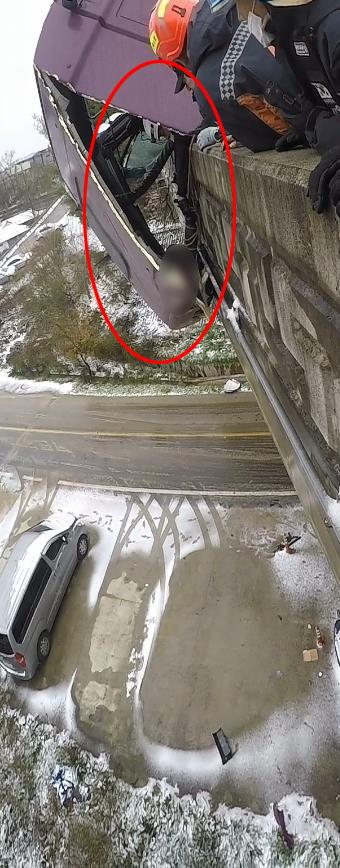 Fire corporal Park Jun-hyeon (wearing white helmet) holds the hands of the unnamed driver to prevent him from falling off the bridge. (Yonhap)