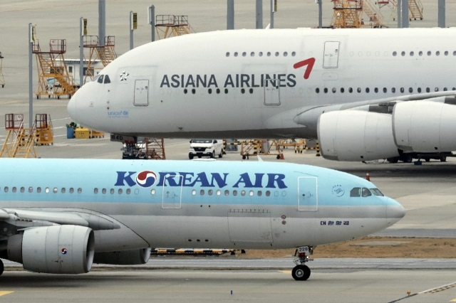 Korean Air and Asiana Airlines planes are parked side by side at Incheon Airport. (Newsis)