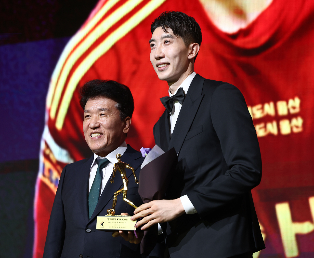 Jo Hyeon-woo of Ulsan HD FC (right) poses with the trophy as the MVP of the 2024 K League 1 season during the K League Awards ceremony at Swiss Grand Hotel in Seoul on Friday. (Yonhap)