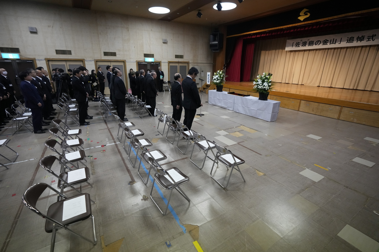 Guests participate in a moment of silence during a memorial ceremony for the Sado Island Gold Mines in Sado, Niigata prefecture, Japan, Sunday, Nov. 24. (AP-Yonhap)