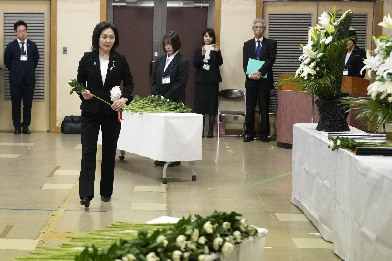 Akiko Ikuina, parliamentary vice minister for foreign affairs, offers a flower on behalf of the government during a memorial ceremony for the Sado Island Gold Mines in Sado, Niigata prefecture, Japan, on Nov. 24. (AP-Yonhap)