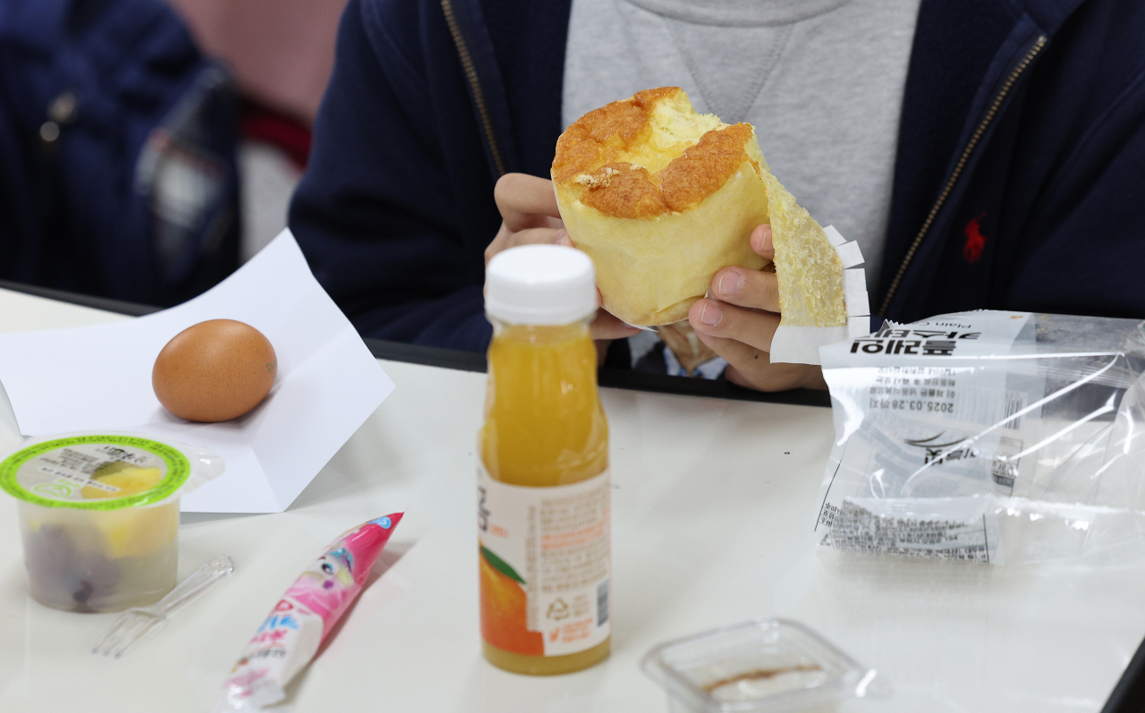 A student at an elementary school in the southeastern city of Daegu eats bread and other substitute foods for lunch after the Daegu branch of a national union for non-regular school workers went on strike on Nov. 21.(Yonhap)