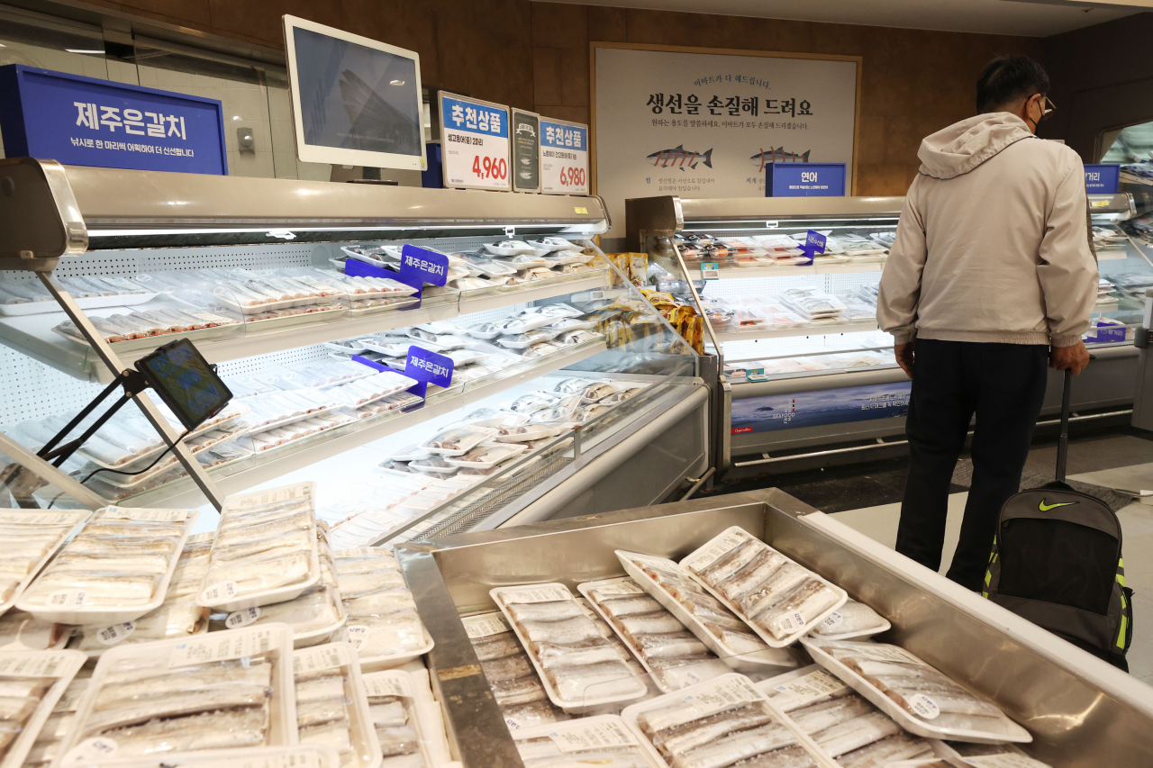 This photo, taken on Nov. 11, shows a shopper looking at fishery products at a supermarket in Seoul. (Yonhap)