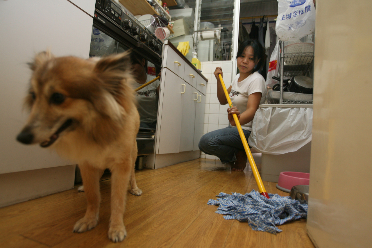 A foreign domestic worker mops her employer's home in Tai Hang, Hong Kong, July 27, 2006. (Felix Wong/South China Morning Post via Getty Images)