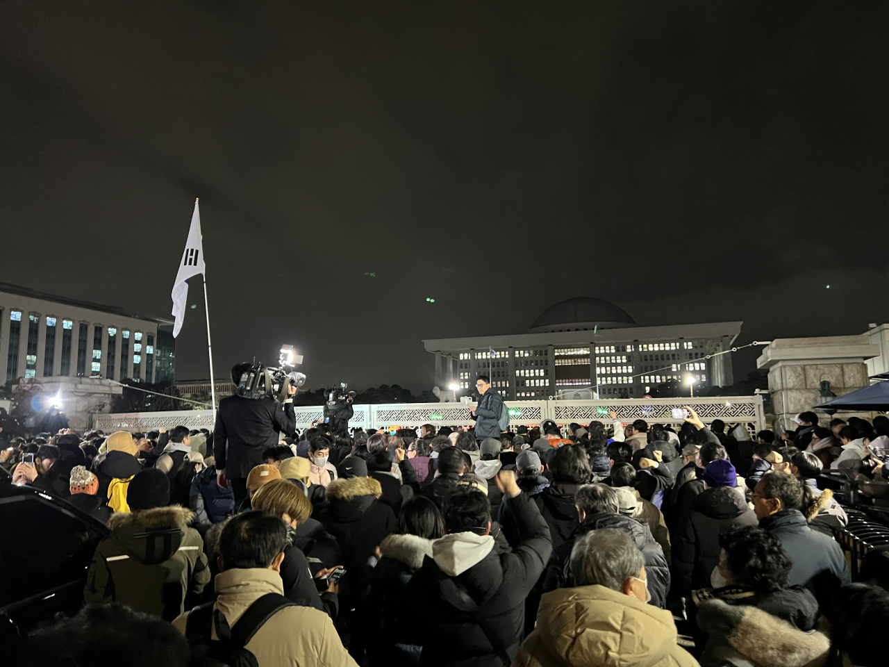 Citizens call to lift the martial law declaration made by President Yoon Suk Yeol in front the National Assembly building in Yeouido, Seoul, Tuesday night. (Kim Jae-heun/The Korea Herald)