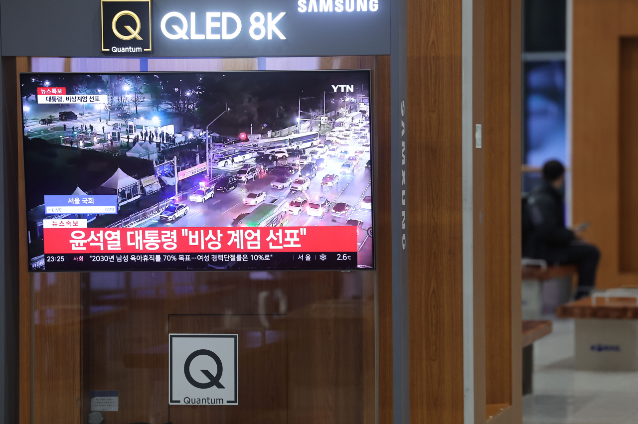 News about martial law is broadcast on the television at Seoul Station in central Seoul on Tuesday night. (Yonhap)