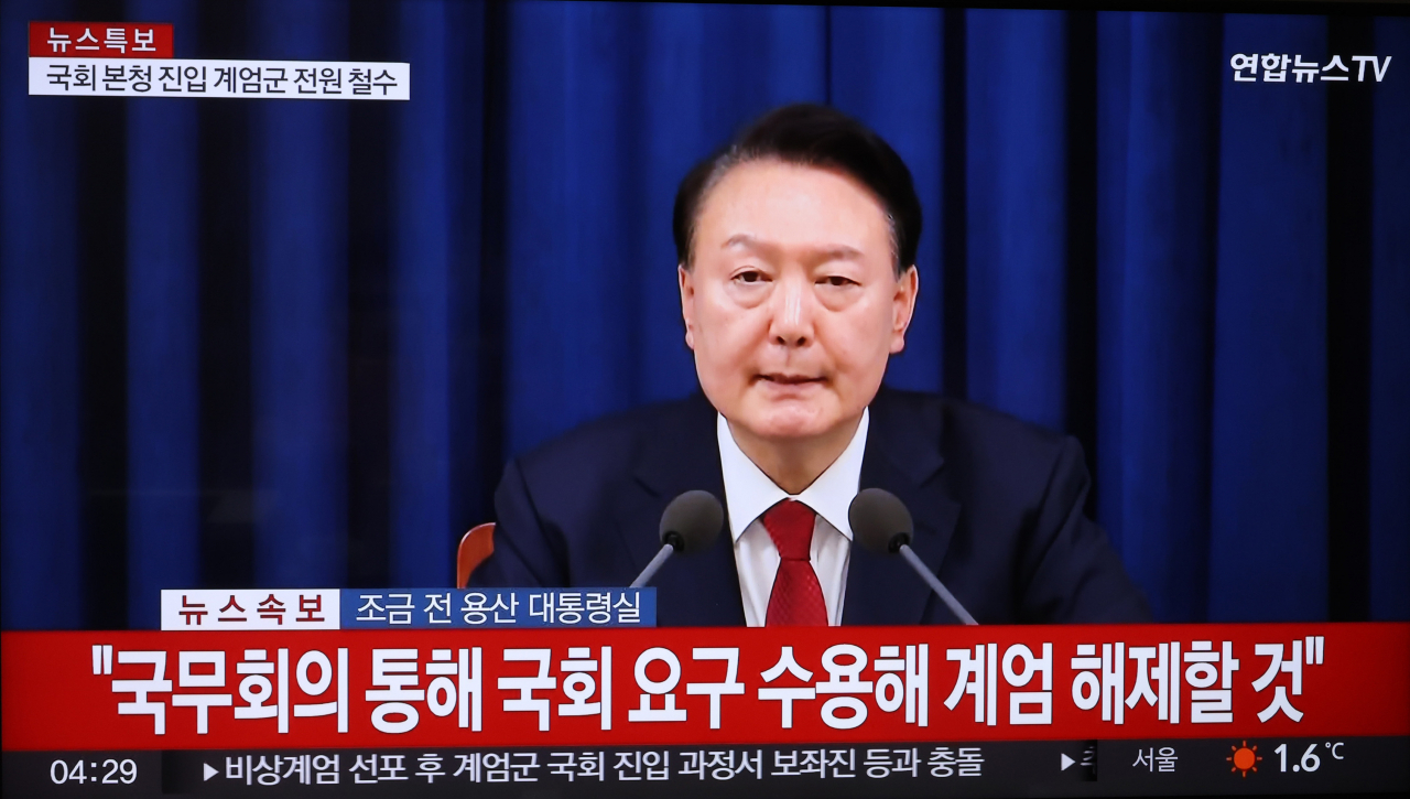 A TV screen shows President Yoon Suk Yeol speak at a televised address to the nation Wednesday morning. (Yonhap)