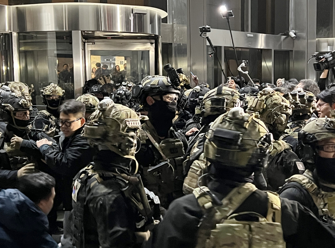 Soldiers stand outside the front entrance doors of the National Assembly main building early Wednesday. (Yonhap)