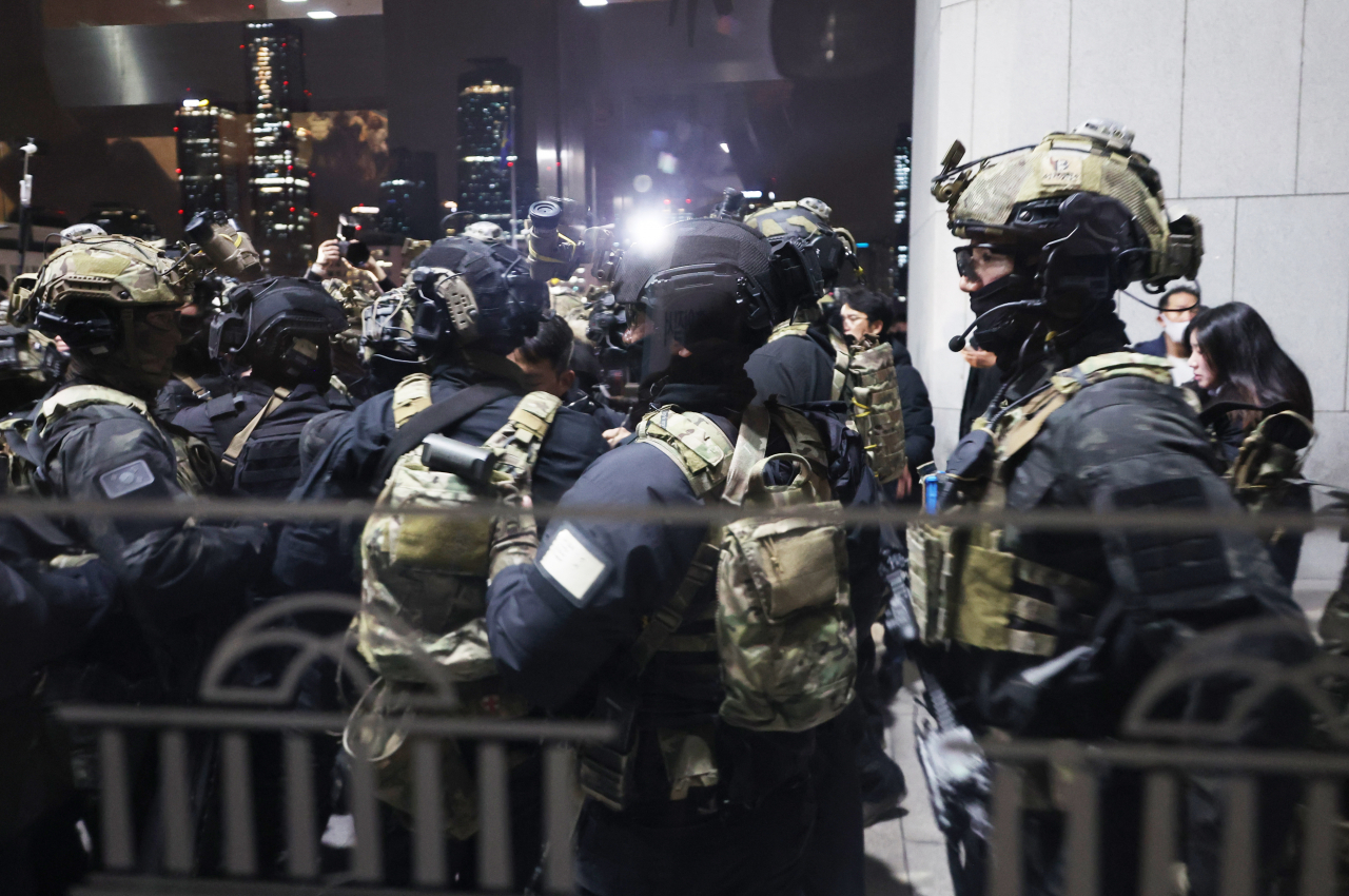 Soldiers stand outside the front entrance doors of the National Assembly main building early Wednesday. (Yonhap)