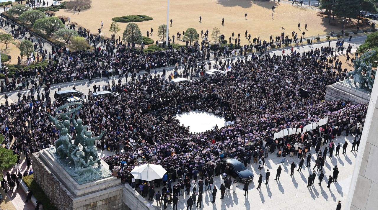 Lawmakers from opposition parties, including the Democratic Party of Korea, the Rebuilding Korea Party and the Progressive Party, along with members of civic groups, hold a rally to demand President Yoon Suk Yeol's resignation and impeachment in front of the National Assembly's main building in Yeouido, Seoul, Wednesday. Yonhap