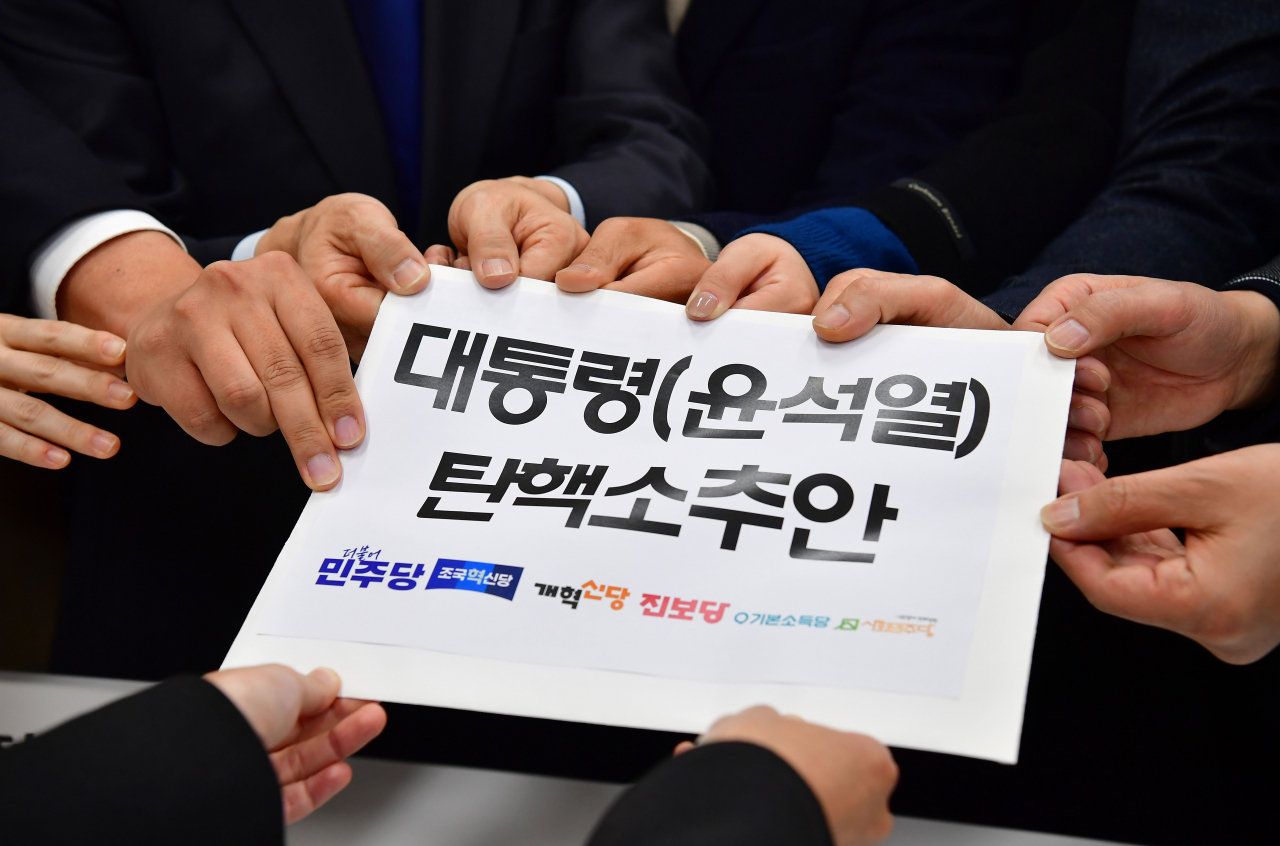 Lawmakers of the main opposition Democratic Party and other minor opposition parties submit a bill to impeach President Yoon Suk Yeol to the bills office at the National Assembly in Seoul on Dec. 4, Tuesday. (Yonhap)