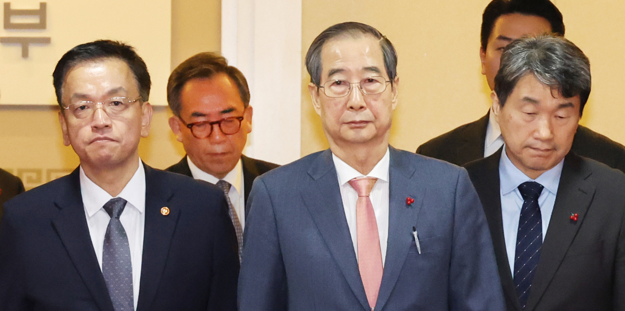 From left: Finance Minister Choi Sang-mok, Foreign Minister Cho Tae-yul, Prime Minister Han Duck-soo and Education Minister Lee Ju-ho walk along the aisle after Han presided over a meeting with the Cabinet members Wednesday morning at the Government Complex Seoul. (Yonhap)