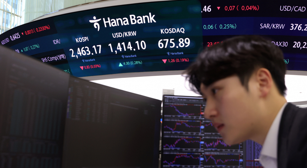 An electronic board displays the Kospi and Kosdaq indices, along with the won-dollar exchange rate, in a trading room at Hana Bank's headquarters in central Seoul Thursday. (Newsis)