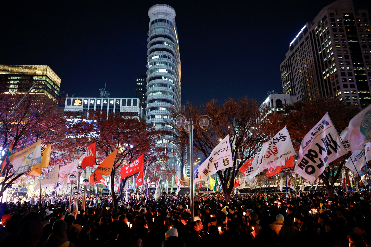 People attend a candlelight vigil condemning South Korean President Yoon Suk Yeol's surprise declaration of martial law last night, which was reversed hours later, and to call for his resignation, in Seoul, South Korea, on Wednesday.