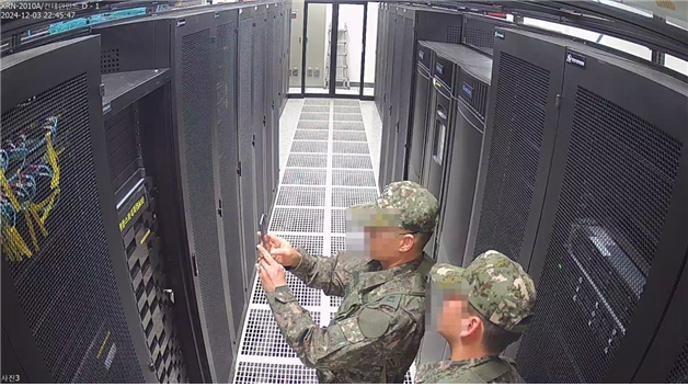 Troops take photos of servers at the National Election Commission in Gwacheon, Gyeonggi Province, on Tuesday. (Yonhap)