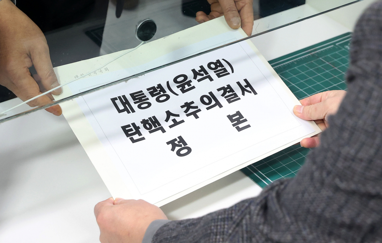 Rep. Jung Cheong-rae, chair of the National Assembly's Legislative and Judiciary Committee, submits the impeachment resolution against President Yoon Suk Yeol to the Constitutional Court in Jongno-gu, Seoul, on Saturday. (Yonhap)