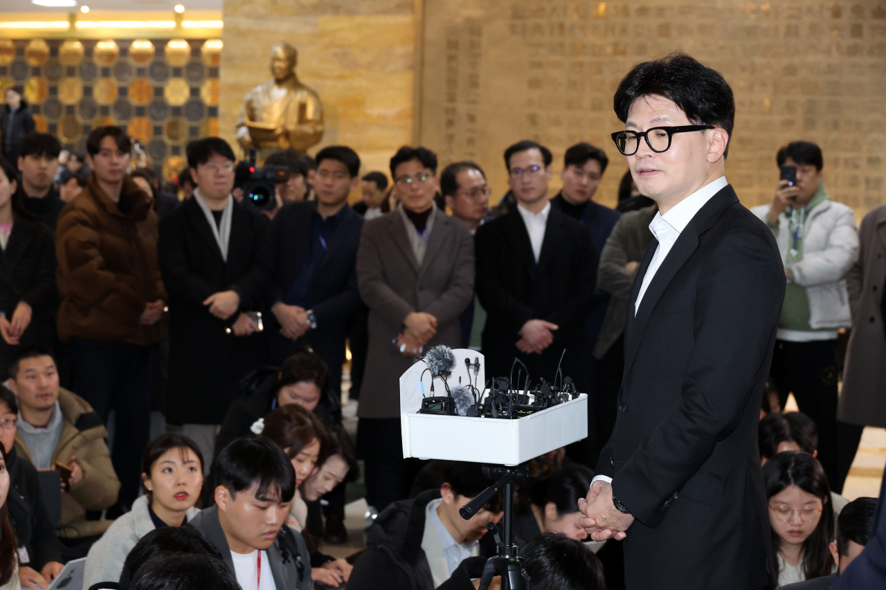 The ruling People Power Party chair Han Dong-hoon answers questions from journalists after the National Assembly voted to impeach President Yoon Suk Yeol, a member of the PPP, in Seoul on Saturday. (Yonhap)