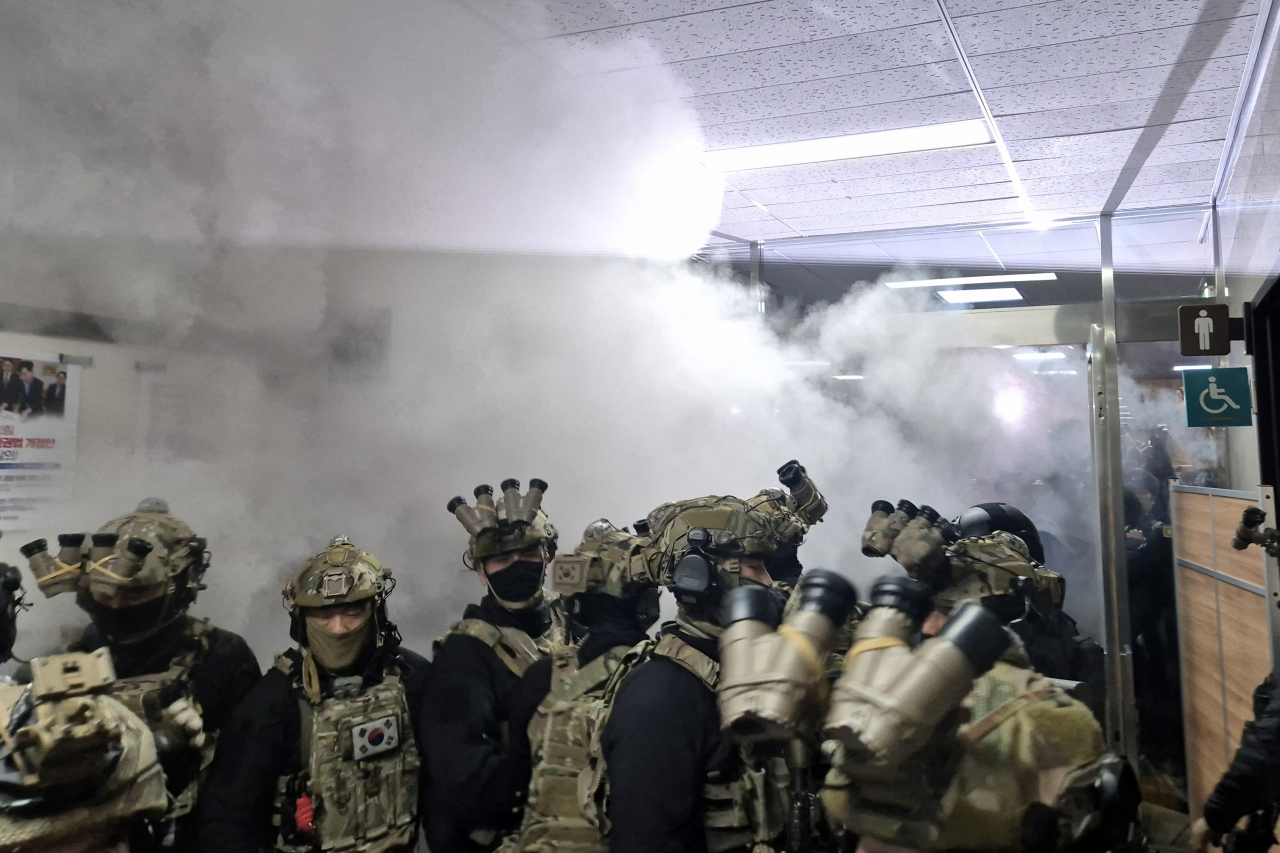 Martial law troops attempting to force their way into South Korea's National Assembly chamber from the People Power Party leader's office are met with resistance from assembly staff wielding fire extinguishers in the early hours of Dec. 4. Yonhap