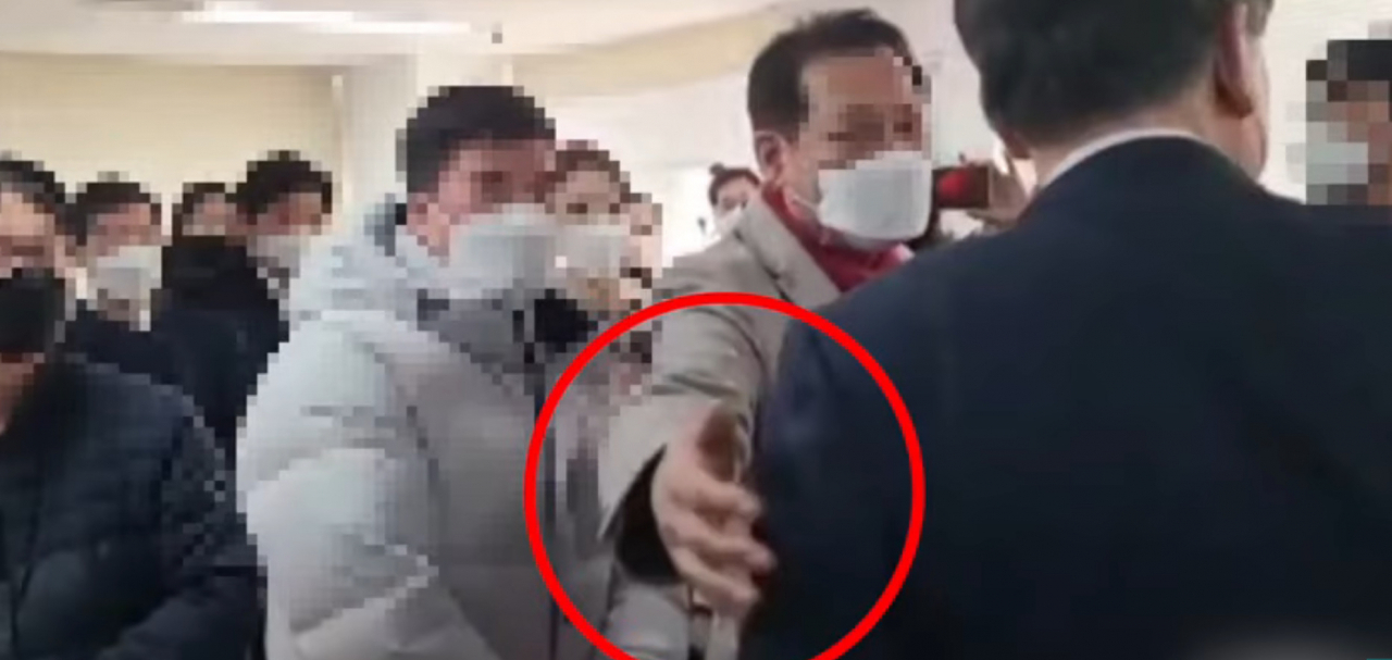 This screenshot image shows the shaman surnamed Jeon making a friendly gesture to then-People Power Party presidential candidate Yoon when he visited his networking subcommittee's office in Seoul. (Segye Times YouTube channel)