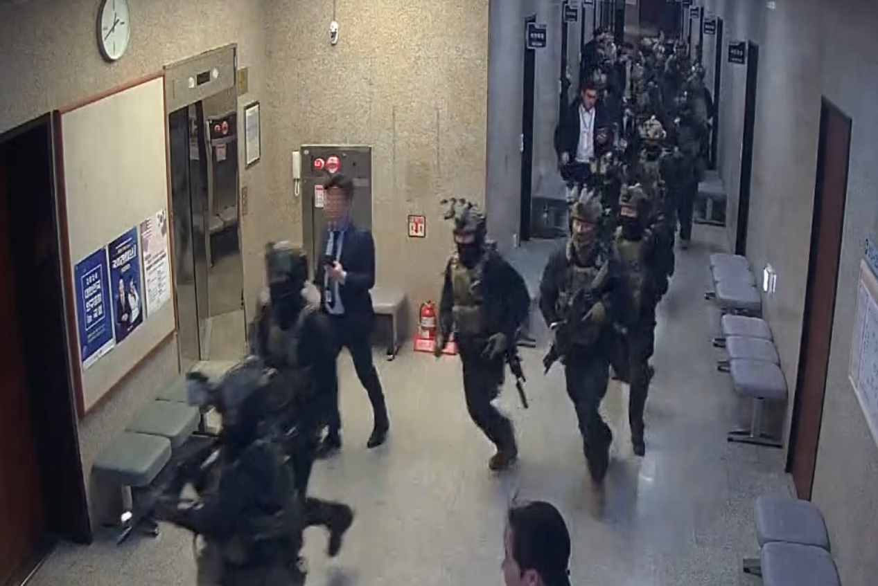 This CCTV footage provided by the National Assembly Secretariat shows martial law command personnel advancing along the aisle on the second floor of the National Assembly in Yeouido, Seoul, on Dec. 4, a couple of hours after the martial law declaration. (Yonhap)