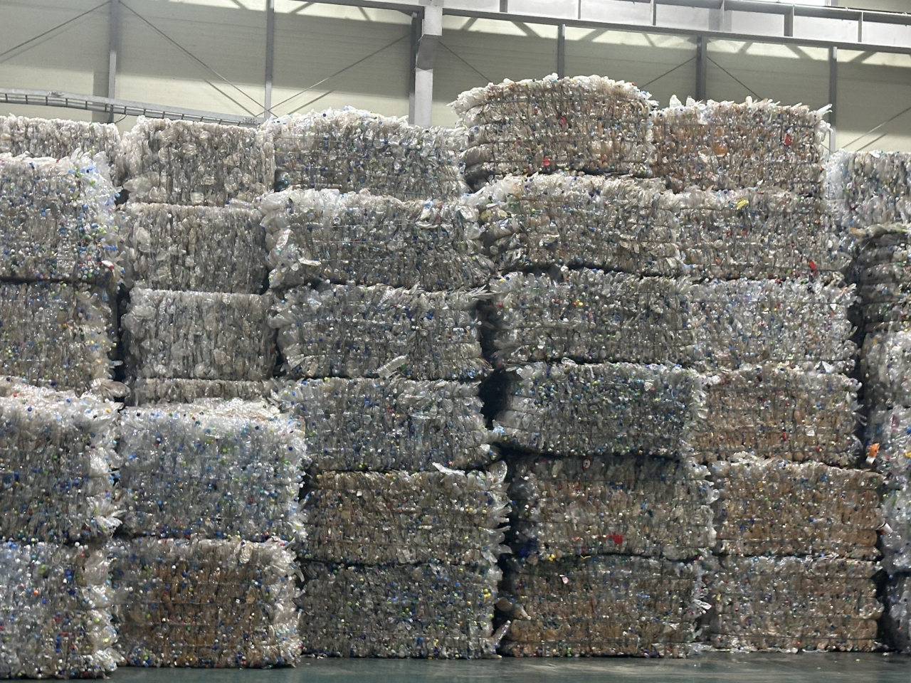 Large sums of compressed plastic bottles are piled up on top of each other at Yuil Industries, a plastic recycling factory, located in Gangseo-gu, Busan. (Lee Jung-joo/The Korea Herald)