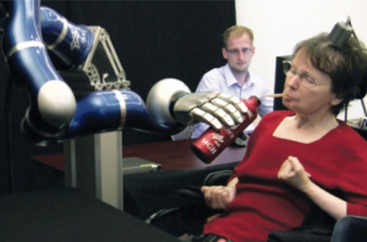 Paralyzed woman uses her mind to control robot arm