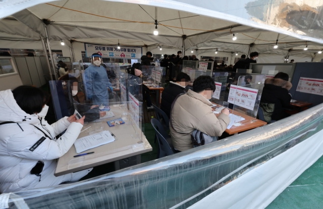 Citizens receive rapid antigen tests at a test center in eastern Seoul on Wednesday. (Yonhap)