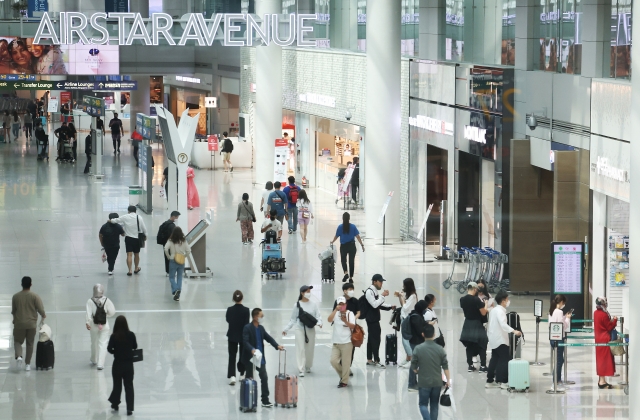 Tourists are seen walking through the duty-free zone at Incheon International Airport on June 5. (Yonhap)