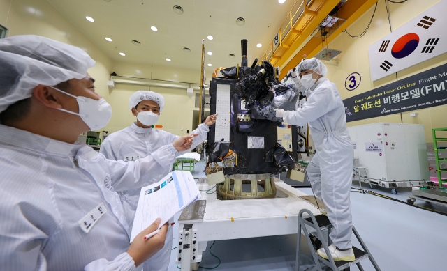 This photo provided by the Korea Aerospace Research Institute in Daejeon on June 6, 2022, shows aerospace engineers inspecting Danuri, South Korea's first lunar orbiter scheduled to be launched into space in early August from Cape Canaveral Space Force Station in Florida. (Yonhap)