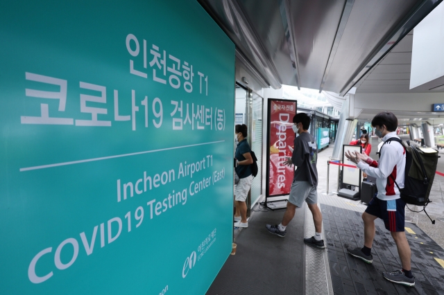 People line up outside a COVID-19 testing center at Incheon International Airport last Friday. (Yonhap)