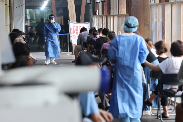 A COVID-19 testing station in Seoul is crowded with people who seek to undergo virus tests on Thursday. (Yonhap)