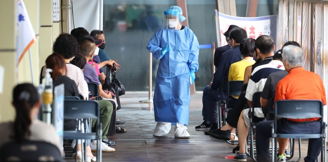 People wait for tests at a COVID-19 testing center in southeastern Seoul on Tuesday. (Yonhap)