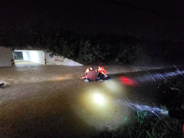 Rescue workers work to save a person from a submerged vehicle in Pohang.