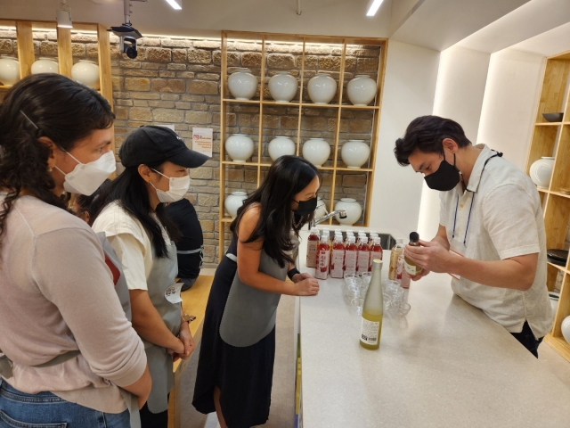 A staff member of the Korean Food Promotion Institute explains traditional Korean liquors to participants. (Choi Jae-hee/The Korea Herald)