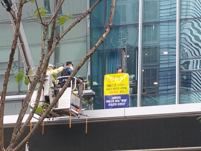 An unidentified man appearing to be an anti-Japanese activist hoists a banner that says 