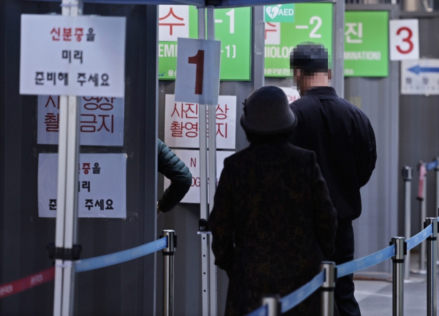 People wait their turn to get tested for the coronavirus at a testing center in Yongsan, central Seoul on Tuesday. (Yonhap)