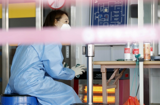 A health worker sits in front of a heater at a coronavirus testing center in Gwangju on Tuesday. (Gwangju Buk ward office)