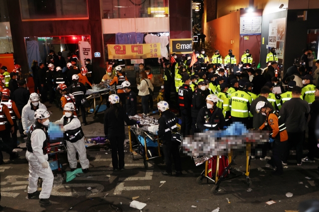 First responders treat patients experiencing cardiac arrest in Itaewon, central Seoul, on Saturday. (Yonhap)