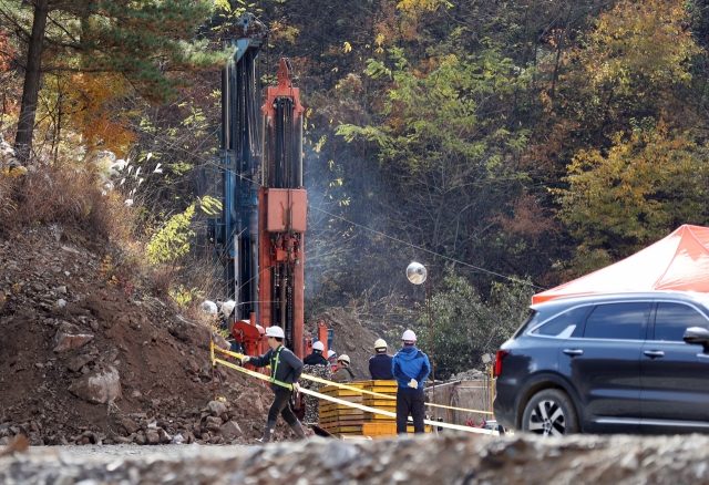 Rescue workers drill a hole to reach two miners trapped inside a zinc mine in Bonghwa, southeast South Korea, on Monday. (Yonhap)