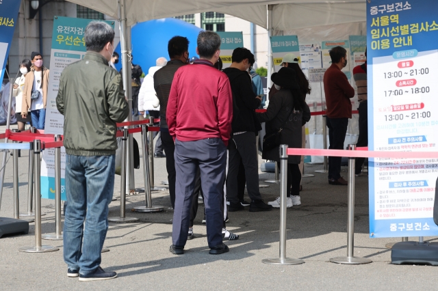 People wait in line at a temporary COVID-19 testing station located nearby Seoul Station, Jung-gu, Seoul on Oct.23. (Yonhap)