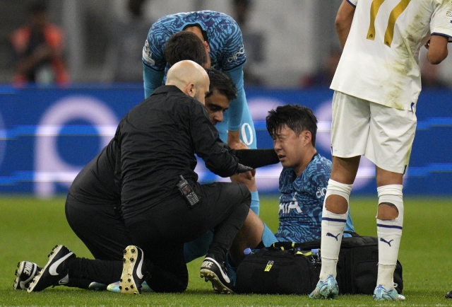 Son Heung-min of Tottenham Hotspur (second from right) receives treatment for a facial injury during the team's UEFA Champions League Group D match against Marseille at Stade de Marseille in Marseille, France, last Tuesday. (AP)