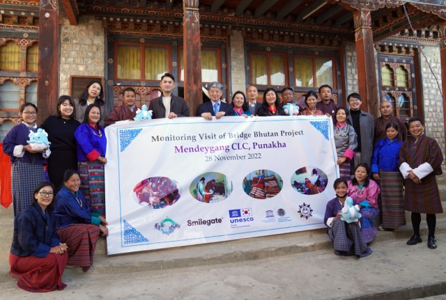 Smilegate Megaport Director Jeong Jae-hoon (sixth from left on the second row) and Secretary General of the Korean Natioanl Commission for UNESCO Han Kyung-koo (seventh from left on the second row) pose for a picture with Bhutanese authorities and local villagers during the opening ceremony of a community learning center in Mendeygang, Bhutan on Nov. 28. (Smilegate)