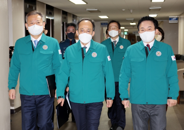 From left: Interior Minister Lee Sang-min, Deputy Prime Minister and Finance Minister Choo Kyung-ho and Transport Minister Won Hee-ryong walk down an aisle to hold a briefing after an extraordinary Cabinet meeting Thursday morning in the Government Complex Seoul. (Yonhap)