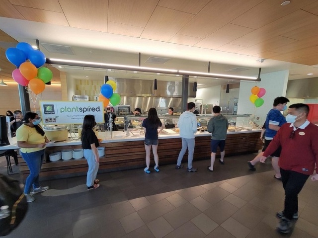 University of Massachussetts Amherst students line up as cafetaria workers serve Pulmuone's plant-based foods. (Pulmuone)