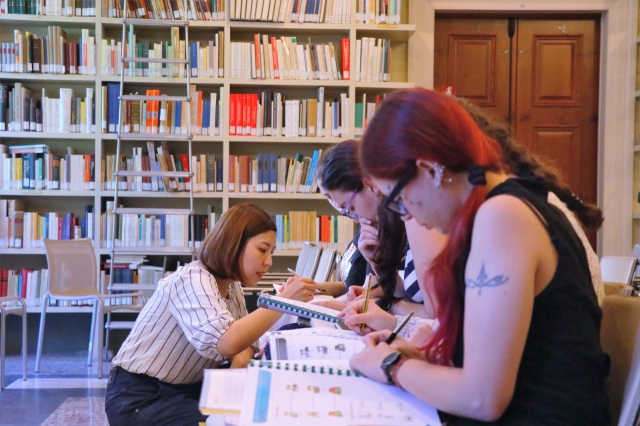 A teacher helps pupils during a Korean class at the King Sejong Institute in Rome. (King Sejong Institute Foundation)