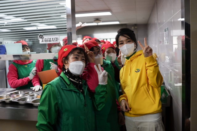 First lady Kim Keon Hee takes a photo with volunteers at the Seongseo Social Welfare Center in Daegu on Wednesday. (Yonhap)