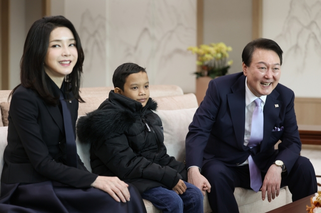 President Yoon Suk Yeol and first lady Kim Keon Hee meet Cambodian boy Aok Rotha who is recovering from heart disease surgery at the presidential office in Yongsan, Seoul, on Tuesday. (Yonhap)